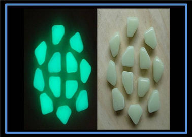 Lueur jaune de matériaux luminescents de couleur verte dans les pierres foncées de jardin