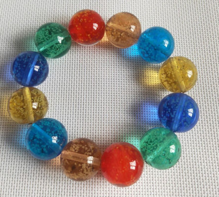 Lueur dans les ficelles en verre foncées de main de différentes couleurs